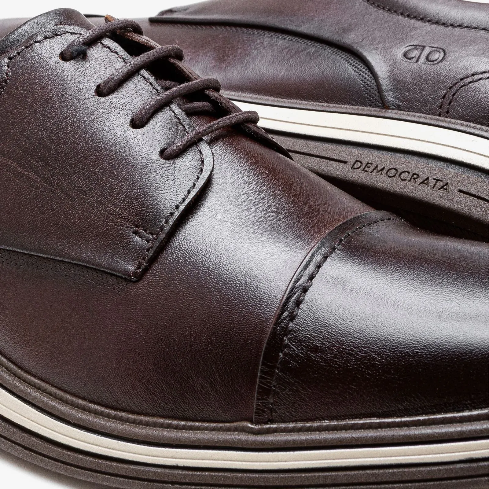 Vista superior e lateral do sapato casual masculino Democrata em couro marrom com estampa interna azul e branca.